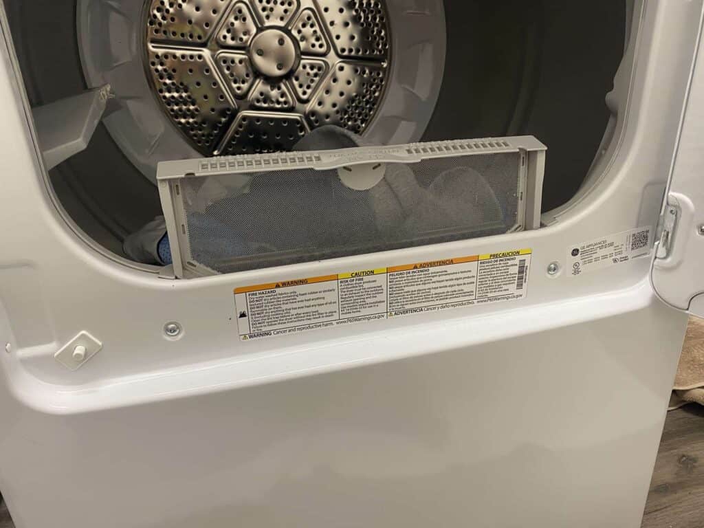 lint trap partially slid out from slot in dryer